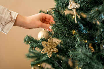 Adding Gold Snowflake Ornament to Christmas Tree