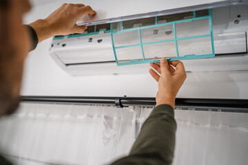 back view of man hand hold air conditioner filter cleaning concept