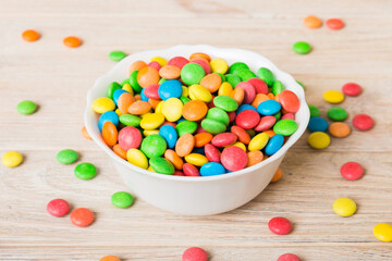 Multicolored candies in a bowl on a colored background. birthday and holiday concept. Top view with copy space