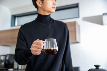 ホットコーヒーを持つ男性の手元