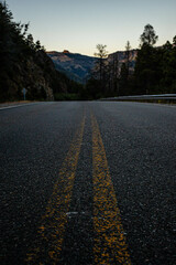 Perspectiva ruta con monta&ntilde;as y bosque, lineas amarillas