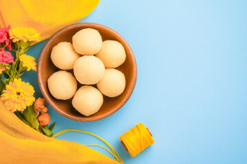 happy Makar Sankranti Festival - Tilgul or Til ladoo in a bowl or plate with haldi kumkum and flowers