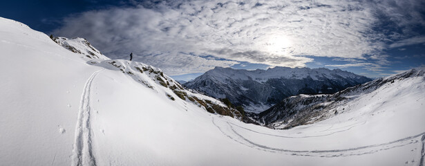Panorama of the french alps in winter. ski touring with skier on top of the mountain.