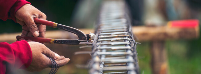 Banner Construction Worker hands using pincer pliers iron wire. Outdoor Worker using wire bending pliers. Banner Men hands bending cutting steel wire fences bar concrete worker with copy space