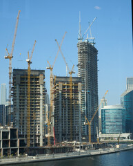 Dubai hohe Baukräne ragen über die teilweise noch offenen Rohbauten, dahinter stehen bereits...