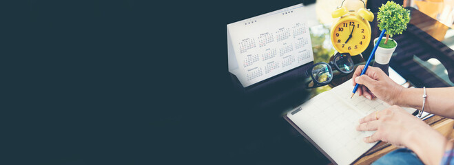 Banner Woman hands writing empty notebook planing meeting agenda on wooden table. Banner Close up women hands using pen planner organizer. Female hand holding Personal Organizer with copy space