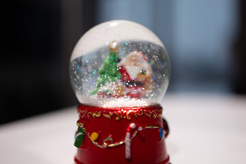 Naklejka premium This charming snow globe features a jolly Santa and a decorated Christmas tree, spreading holiday cheer to all
