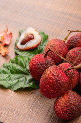 Fresh lychee with leaves isolated on wooden background.