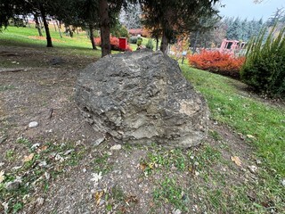A large grey rock in the park. Dark coloured rock with many cracks and crevices, grey and black colours. Dikmen Valley, Ankara, Turkey.
