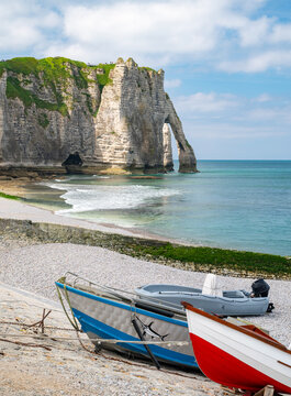 Fischerboote liegen vor den malerischen Felsen am Meer in Etretat, Normandie, Frankreich