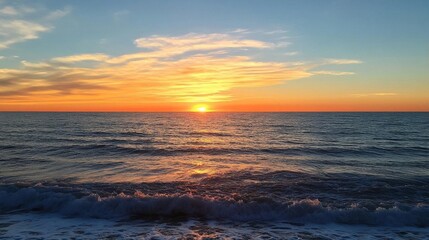 A serene sunset over the ocean, casting vibrant colors on the water.