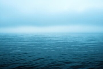 Fototapeta premium A serene view of calm ocean waters under a misty atmosphere.