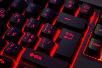 The image shows a part of the keyboard with backlighting. The keys have red backlighting, and the symbols on them are also made in red. The keys "Shift", "Enter", "Delete", "Insert" are visible