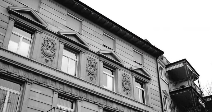Low-angle shot of a luxury real estate building in Baden-Baden showcasing intricate architectural details, including crest engravings and classical design elements