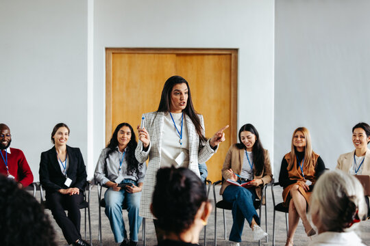 Female instructor addressing a diverse group during a seminar in a bright conference room