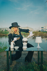 Glamorous , stylish woman cuts mannequin's head in nature. Fashion Concept, barbershop barber