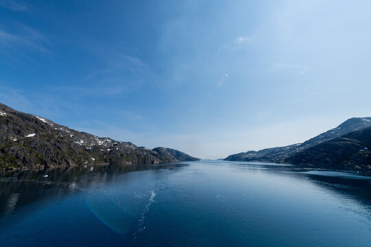 Prins Christian Sund Greenland mountain fjord with floating ice and shore iceberg on a summer day