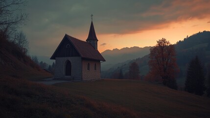 Fototapeta premium A tranquil chapel rests on a hillside, surrounded by stunning mountain silhouettes as the sky transitions into shades of orange and purple at dusk, creating a peaceful ambiance.