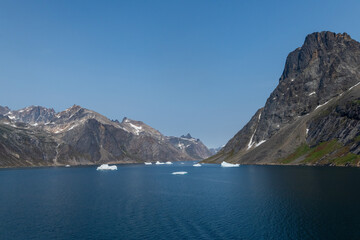 Prins Christian Sund Greenland mountain fjord with floating ice and shore iceberg on a summer day