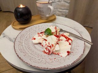 Meringue and mascarpone dessert on dish on small round table