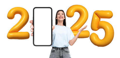 Happy woman showing blank smartphone screen, surrounded by yellow 2025 balloons on white...