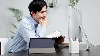 資料を調べてトラブルを解決する男性