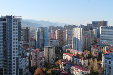 Naklejka premium Multi-level chaotic development in Batumi, Georgia, on a sunny day. The variety of architectural styles and high-rise buildings forms a unique urban landscape 