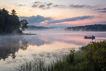 Fototapeta premium A mist-covered lake with soft colors from the morning sky reflected