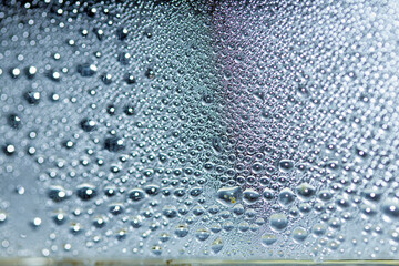 Blue Rain Bubbles Drops Running down a Window on a Wet Day Abstract Background