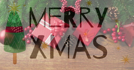 Obraz premium Merry Xmas text image over Christmas gifts and decorations on wooden background