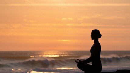 Fototapeta premium A person meditating at sunset by the ocean, promoting tranquility and mindfulness.