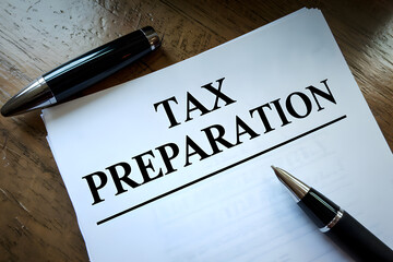 Obraz premium Tax submit preparation online concept. Tax preparation document with pens on a wooden surface.