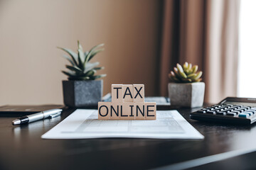 Tax submit preparation online concept. Tax preparation workspace featuring "Tax Online" signage and plants.