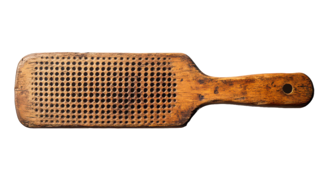 Handmade wooden paddle with intricate perforated design, showcasing craftsmanship and vintage aesthetics