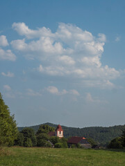 Summer view of old historical Bohemian village Zdirec Borejov with Church of St. James in in Baroque architectural style and green meadow and trees, Kokorin region, central Bohemia