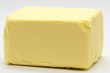 Piece of butter on background. Piece butter white background of lies. A white piece of butter lies on a white background. A block of butter on a white lifestyle background.