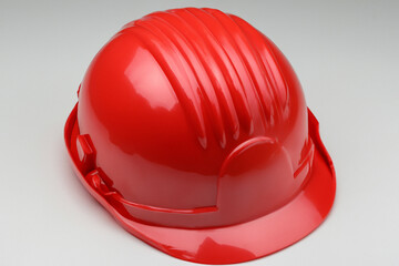 Fototapeta premium Helmet with gray and orange background. Orange helmet gray background construction worker lies. A construction worker lies on a construction helmet. A red hard hat on lifestyle a white background.