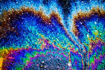 Fototapeta premium Oil stain on Asphalt road after rain, color Gasoline fuel spots on Asphalt Road