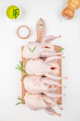 Fresh organic quails meat on white table on a wooden board, top view