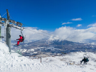 Chairlifts at a ski resort with a snow volcano in the background (Niseko, Hokkaido, Japan)