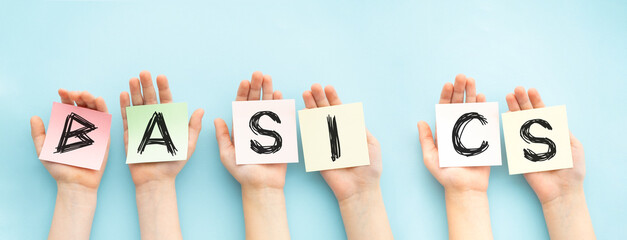 The word Basics that appears on the sticky notes in the hands. Education concept