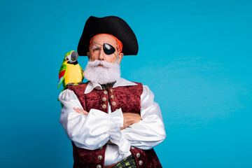 Photo of mature man dangerous robber in pirate costume crossed arms empty space isolated on blue...