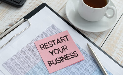 restart your business. light gray background with notepad. text on sticker