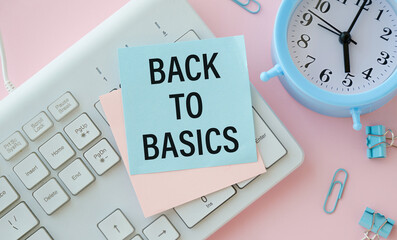 BACK TO BASICS text in office notebook with keyboard, magnifier and glasses.