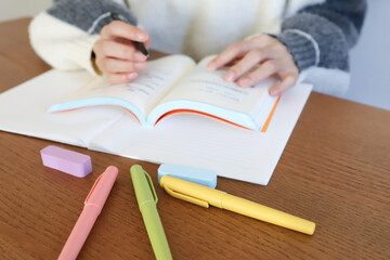 参考書を片手に勉強する手元
