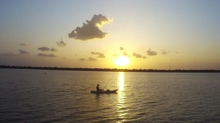 Obraz premium Sunset Kayak Fishing: A Serene Evening on the Lake