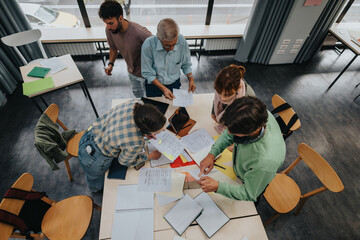A group of college students work together on a project under the guidance of an elderly professor...