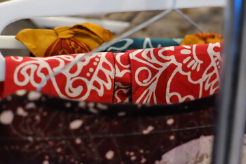 An array of Indonesian batik shirts and batik cloth hangs on the racks, displaying a variety of patterns and colors.