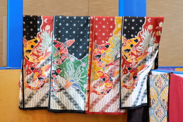 An array of Indonesian batik shirts and batik cloth hangs on the racks, displaying a variety of patterns and colors.