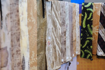 An array of Indonesian batik shirts and batik cloth hangs on the racks, displaying a variety of patterns and colors.